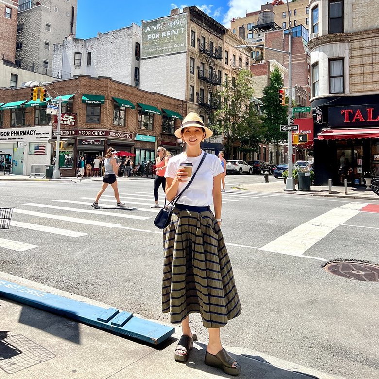 ニューヨークの街角でリラックスした表情の久保さん。Tシャツ姿が若々しい！