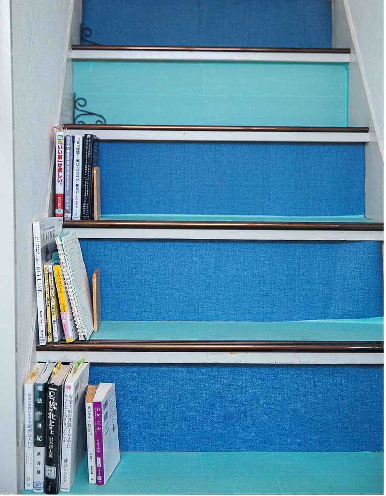 階段に2色のリメイクシートを貼っただけで、パッと明るい雰囲気に。この階段は図書館で借りた本の専用棚にもなっている