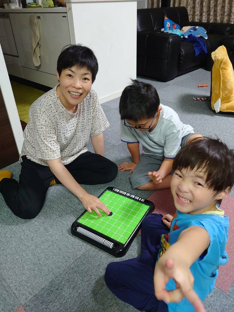 床に座って、子ども達とくつろぐ山田さん親子。つい顔がほころびます
