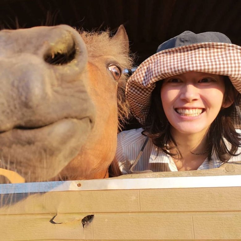 馬小屋の中で馬と戯れる佐藤藍子さん