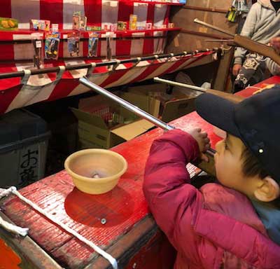▲花園神社の酉の市にて射的に挑戦する息子・晴太朗。これで泥棒が来ても撃退できる！