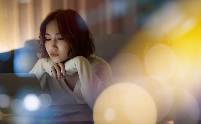 夜にテレワークする女性
