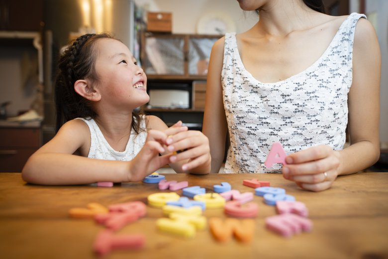 Mother and daughter studying the alphabet