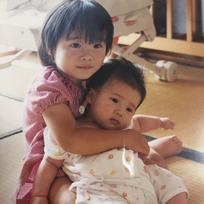 妹を抱っこする幼少期のとんずさん（写真左）