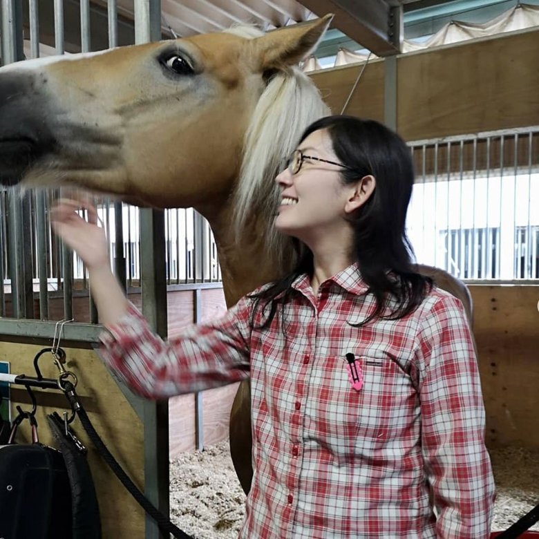 馬小屋で癒やしの時間を過ごす佐藤さん