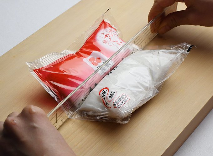 物差しに力を込めて袋ごとカット！