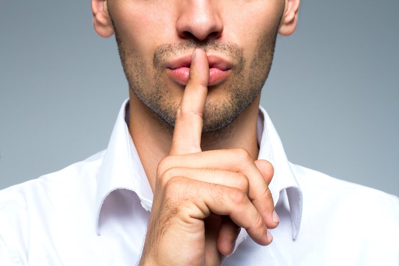 Businessman silent quiet gesture with finger