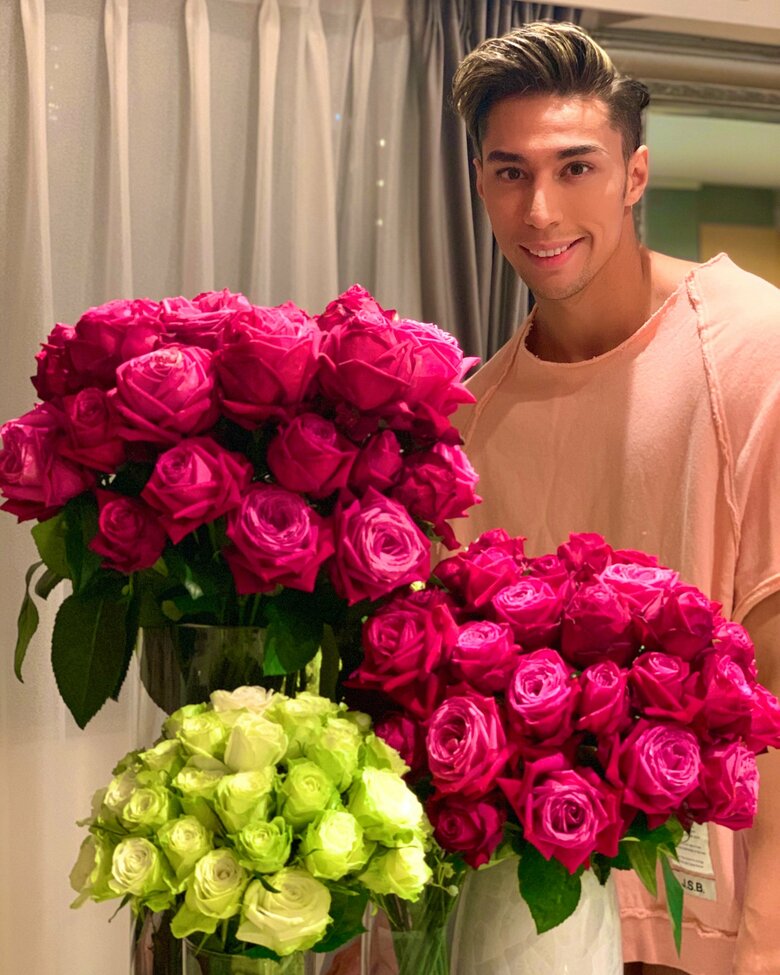 美しいロスフラワーに囲まれる當間ローズさん。