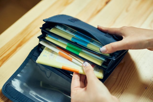 無印良品の母子手帳ケースに、子ども別に色分けする印をつけて管理している