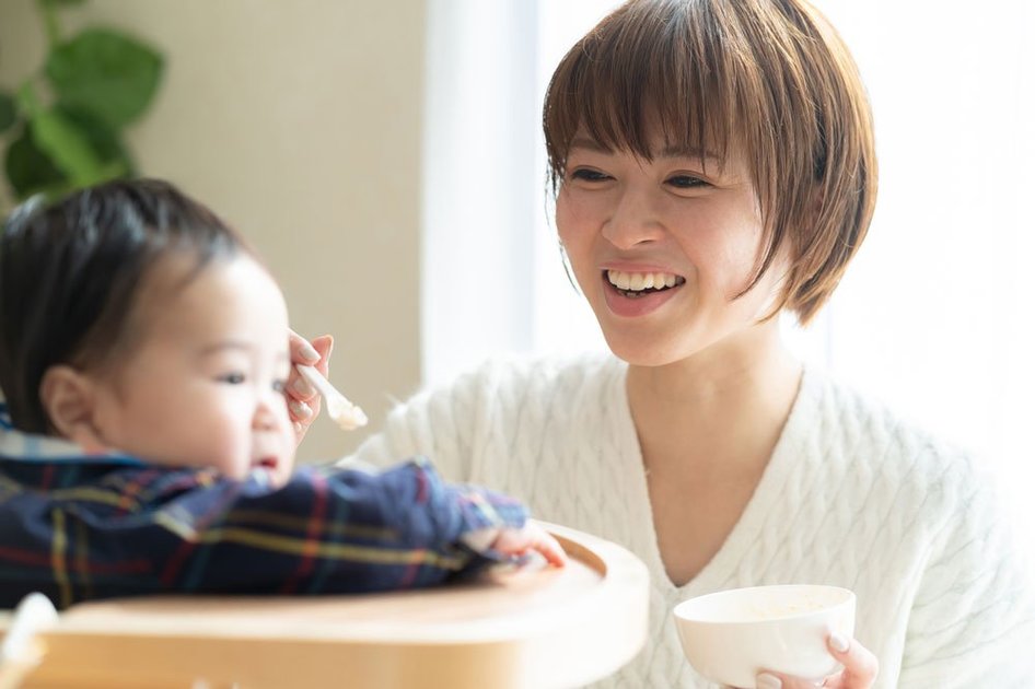 離乳食をあげる母親