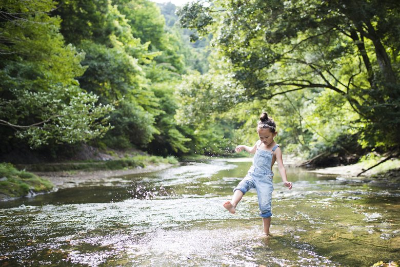 Little girl playing on a stream