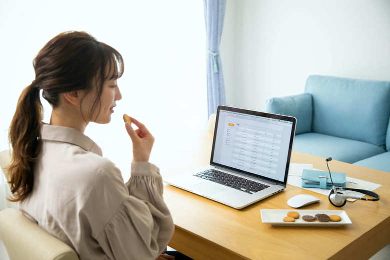 テレワーク中にお菓子を食べる女性