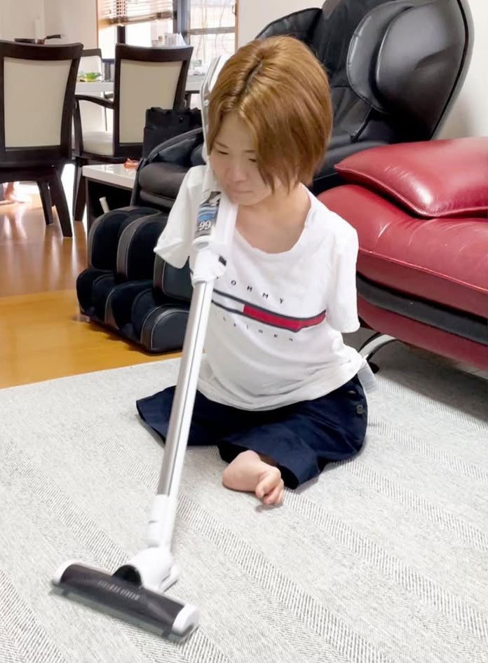 掃除機を肩にかけて掃除