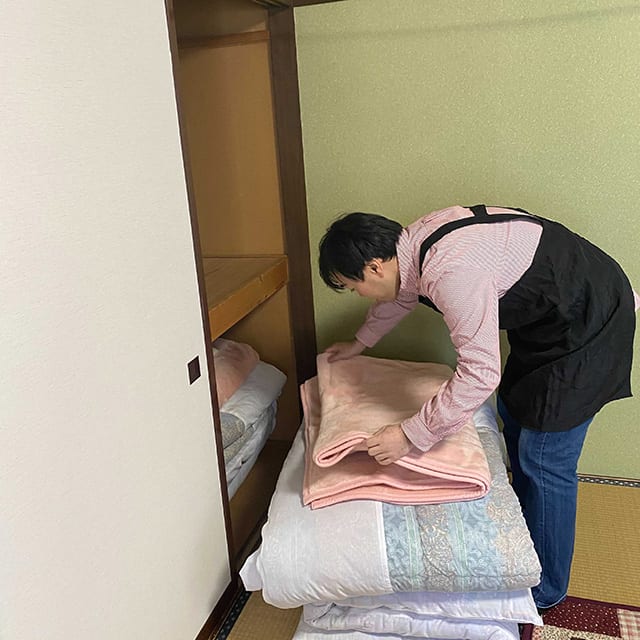 冬の間の土日にエプロンをつけて実家の旅館で働く角谷さん