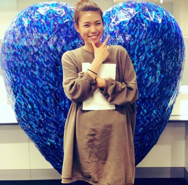 ハートマークの前で婚姻届を手にする紺野さん