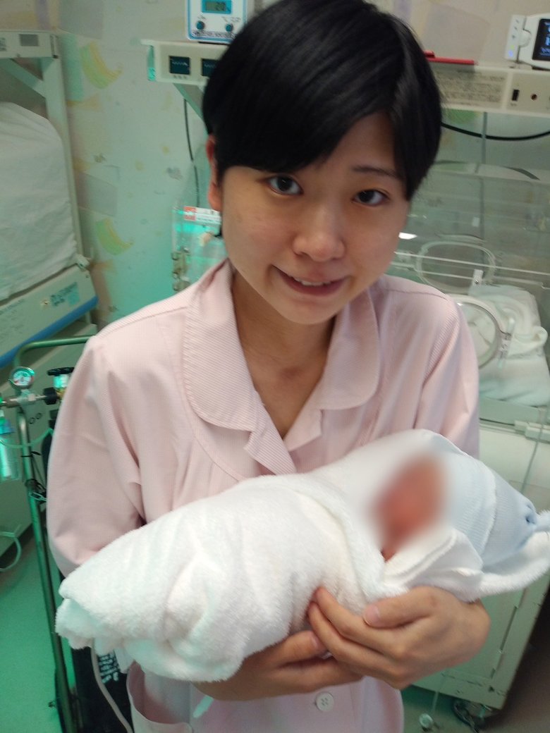 産後間もない息子さんを抱く酒寄さん