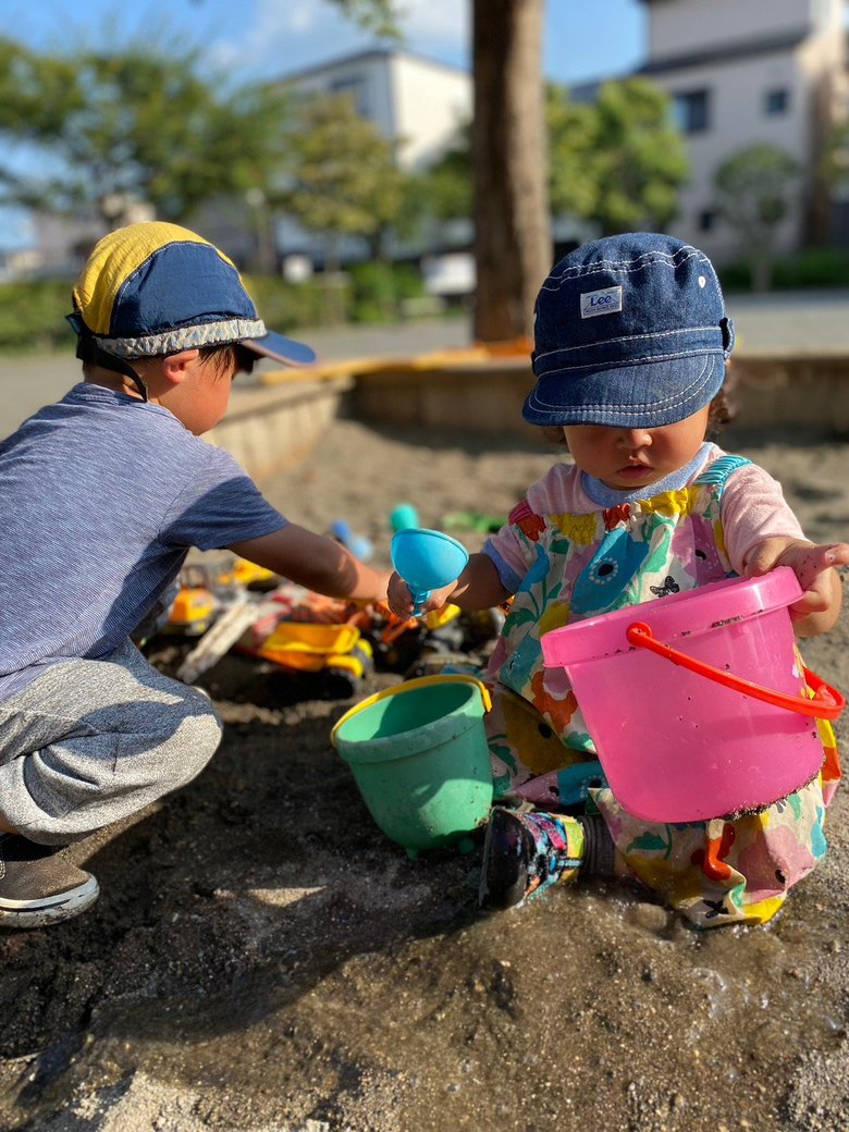 砂場でバケツとスコップを持って、熱心に遊ぶ武内さんの長男と長女