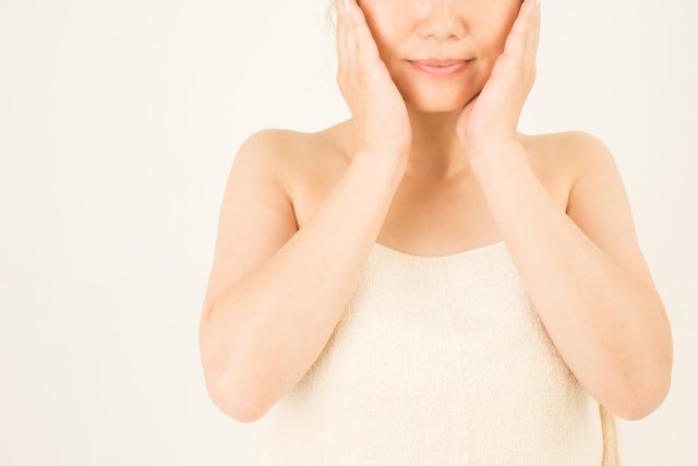 顔のむくみをマッサージで解消する女性の画像