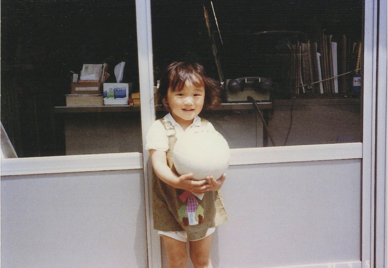 昔の赤城フーズ株式会社本社事務所前に立つ幼少期の遠山さん