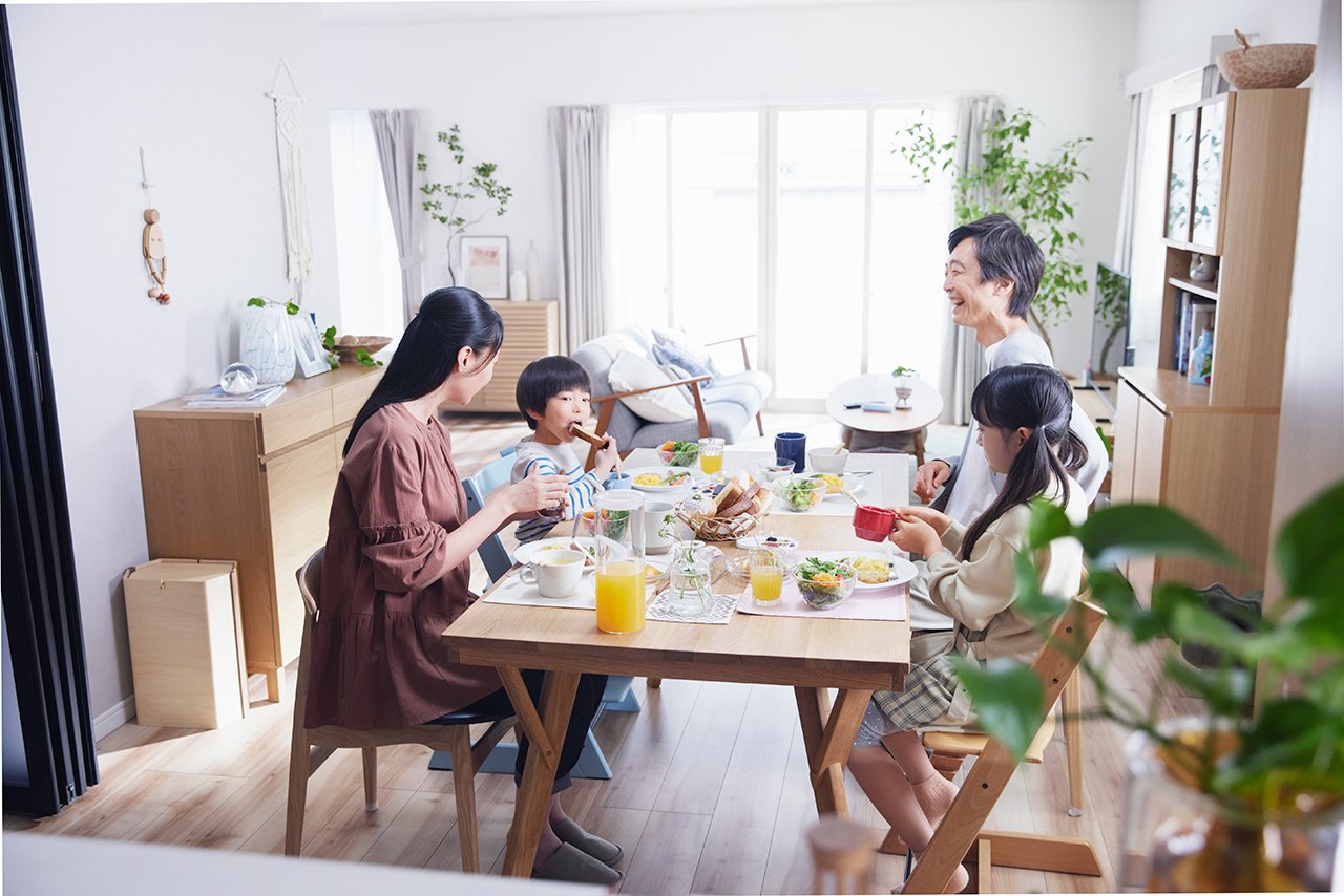 食卓で朝食をとる家族のイメージ