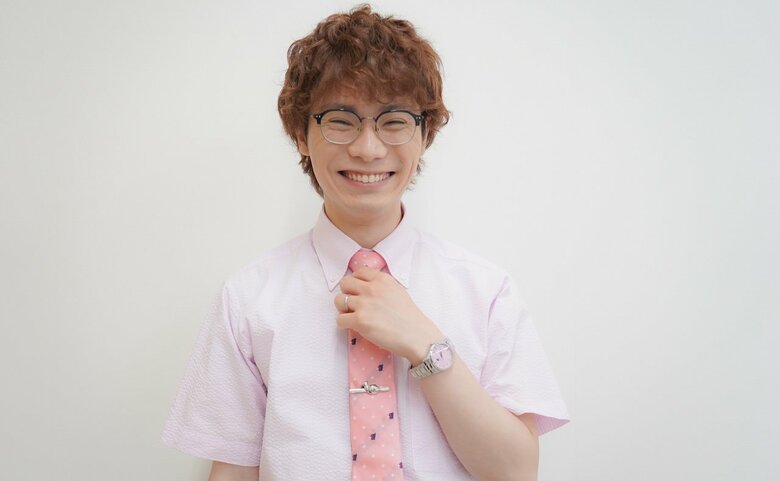 ピンクの衣装で笑顔の鈴木浩文さん
