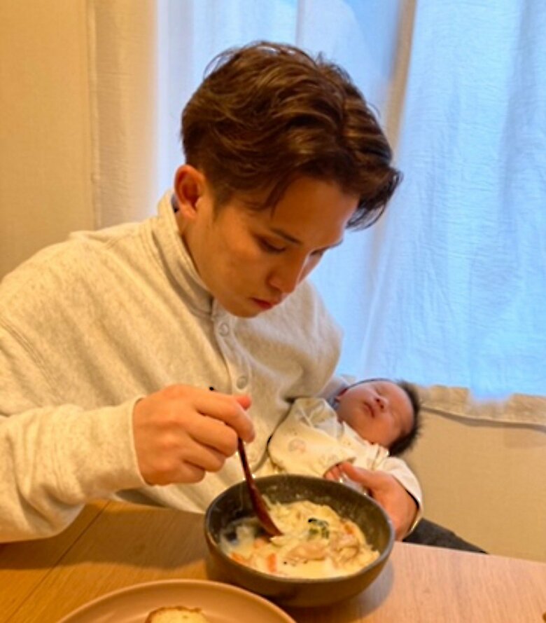 生後1か月の上の子を抱っこしながら食事をとる石黒さん