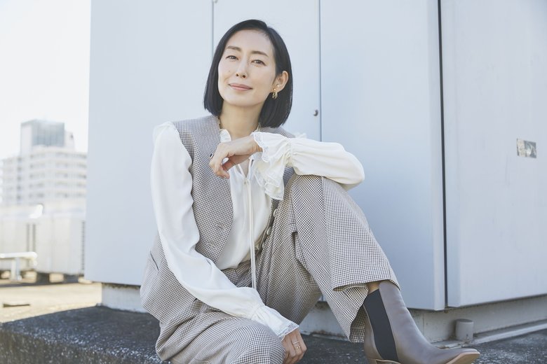 パンツスーツと茶色のブーツをサラッと着こなす木村さん