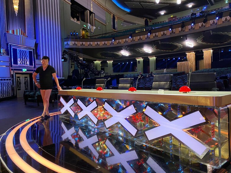 全英を沸かせた人気番組の審査員席でモデルのようなポーズを決める安村さん／(c)FANY マガジン