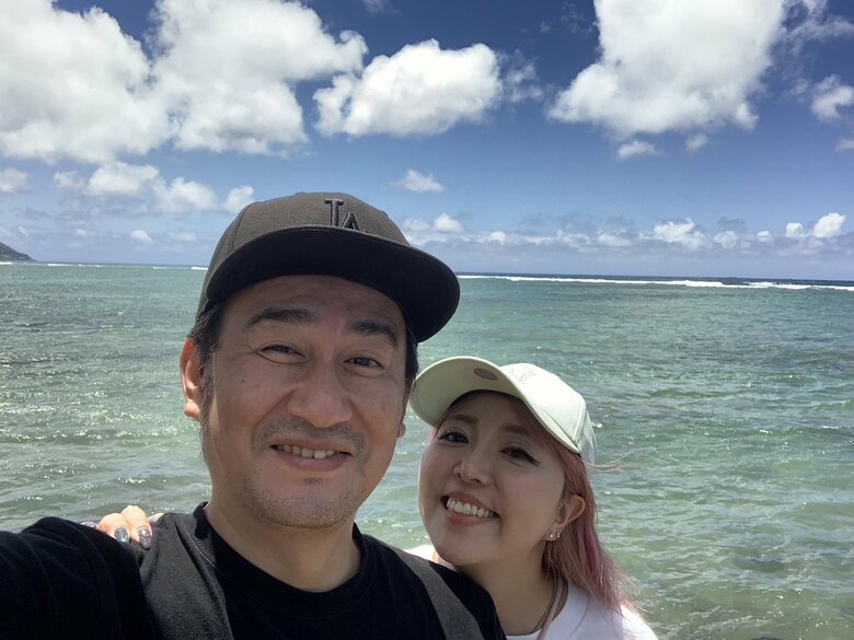 ハワイの海をバックに幸せいっぱい