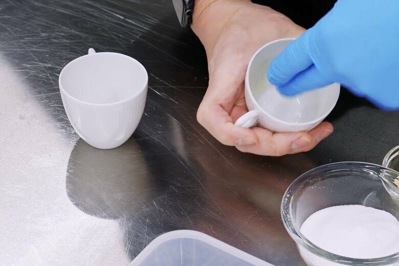 【スフレの型の作り方1】直径7cmのティーカップの内側の側面に柔らかくしたバターを塗る。焼いた際、真上に伸びてくるスフレが綺麗に上がるよう、カップの縁までバターを塗る