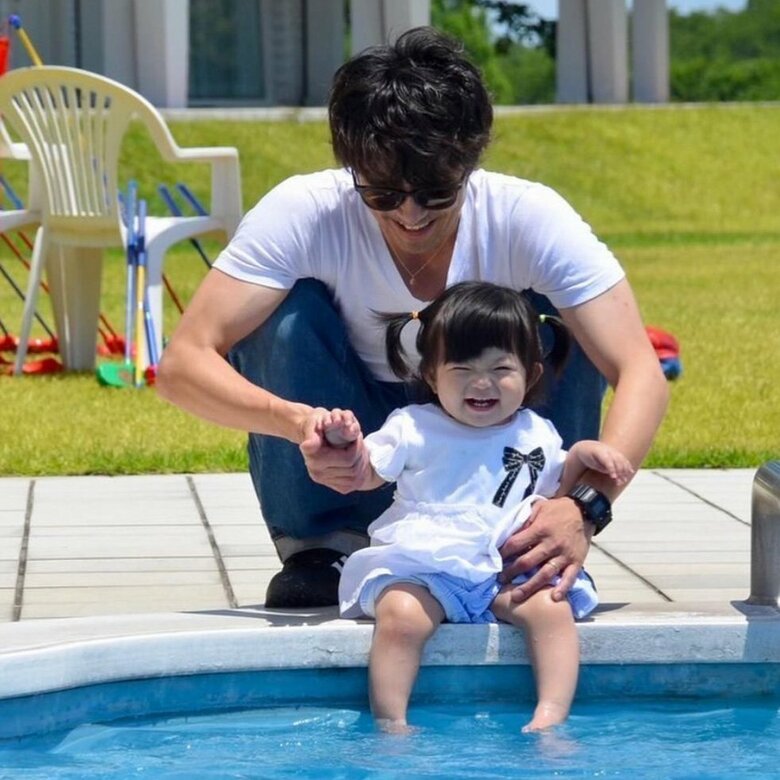娘と水遊びをする斉藤祥太さん