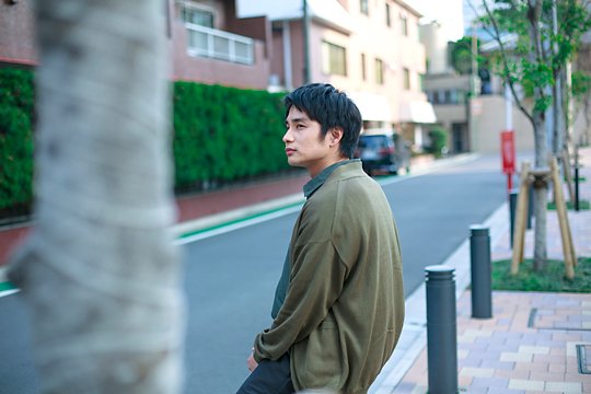 腰掛けて座る中村蒼さん