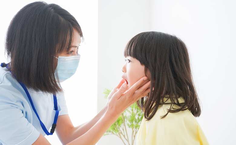 歯医者さんに見てもらう小さな女の子