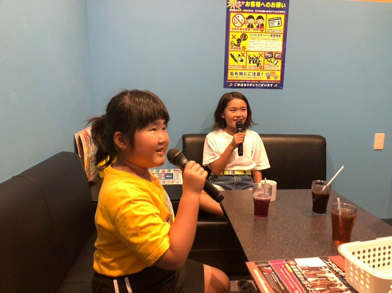 一緒にカラオケを楽しむ小学生のころの二人