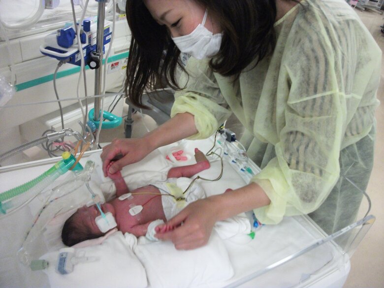 生後1か月で保育器の外に初めて出たいっくんをあやす山崎さん