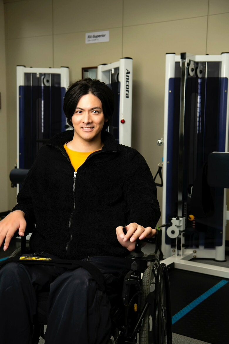 自転車事故で首から下が動かない状態だったが、リハビリにより車いすに乗って活動できるまで回復した