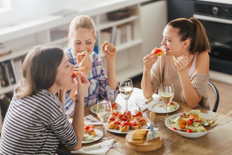 Photo of three women enyoing appetizers and wine