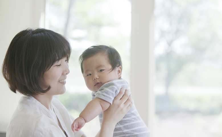 赤ちゃんを抱く母親