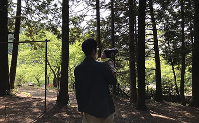 息子を屋外で抱っこする夫