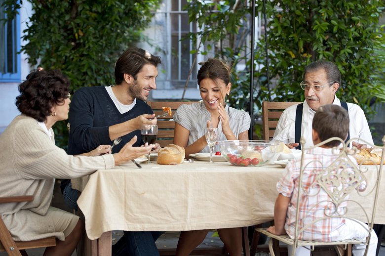 Three generations of a family eating in the garden