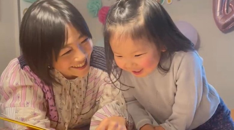 4歳の誕生日を迎えた娘さんと自宅で本を読む久保田さん