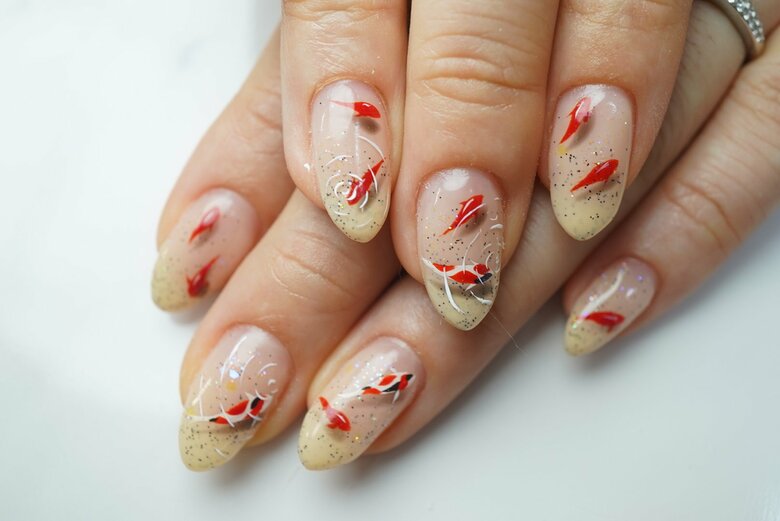 池の鯉も爪で泳ぎ出す