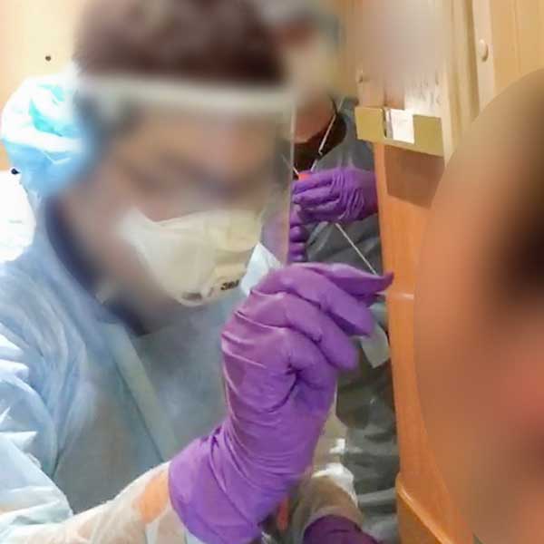 船内でPCR検査を受ける幸子さん（右）。鼻の中に綿棒を入れられている（プライバシー配慮のため一部修正）