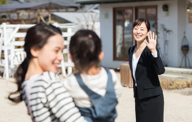 子どもに手を振る女性