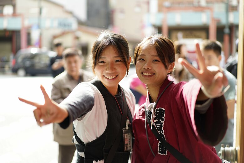 元気に人力車を走らせる女性俥夫にカメラを向ける観光客も多い