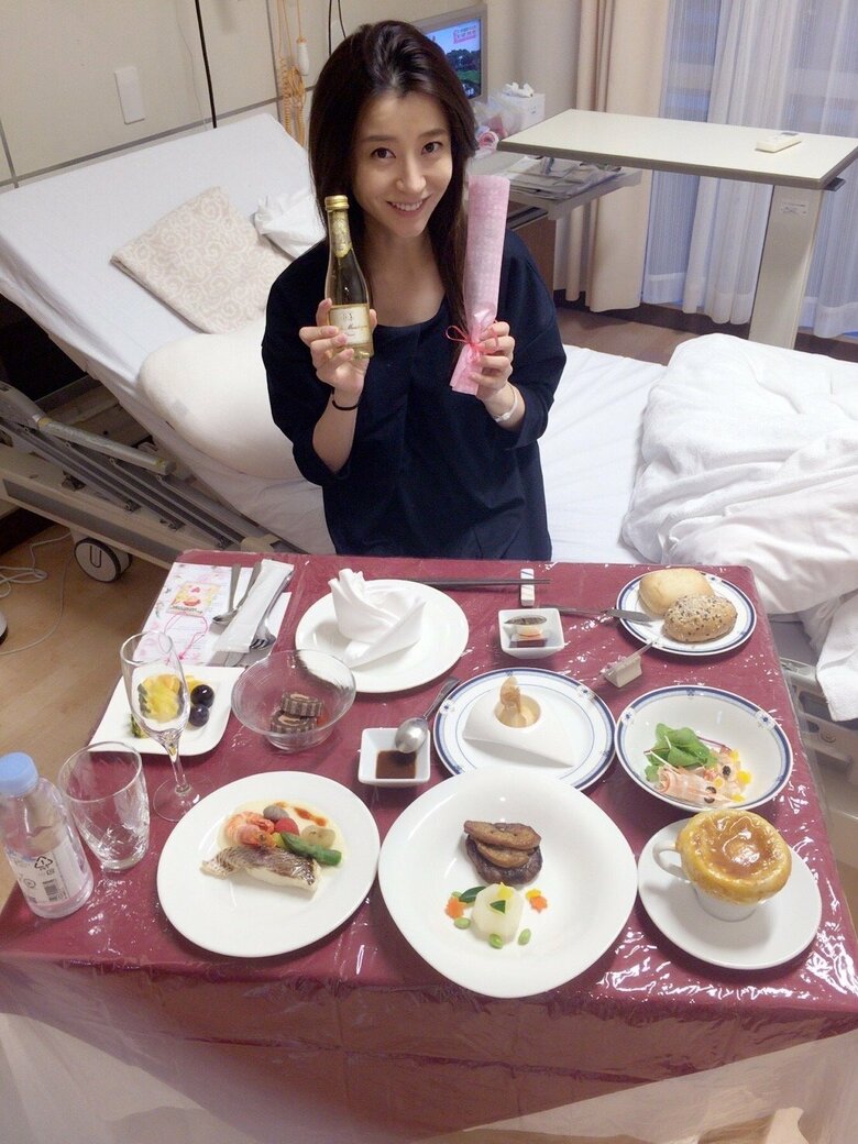 産後、病院でのお祝い膳を前に笑顔