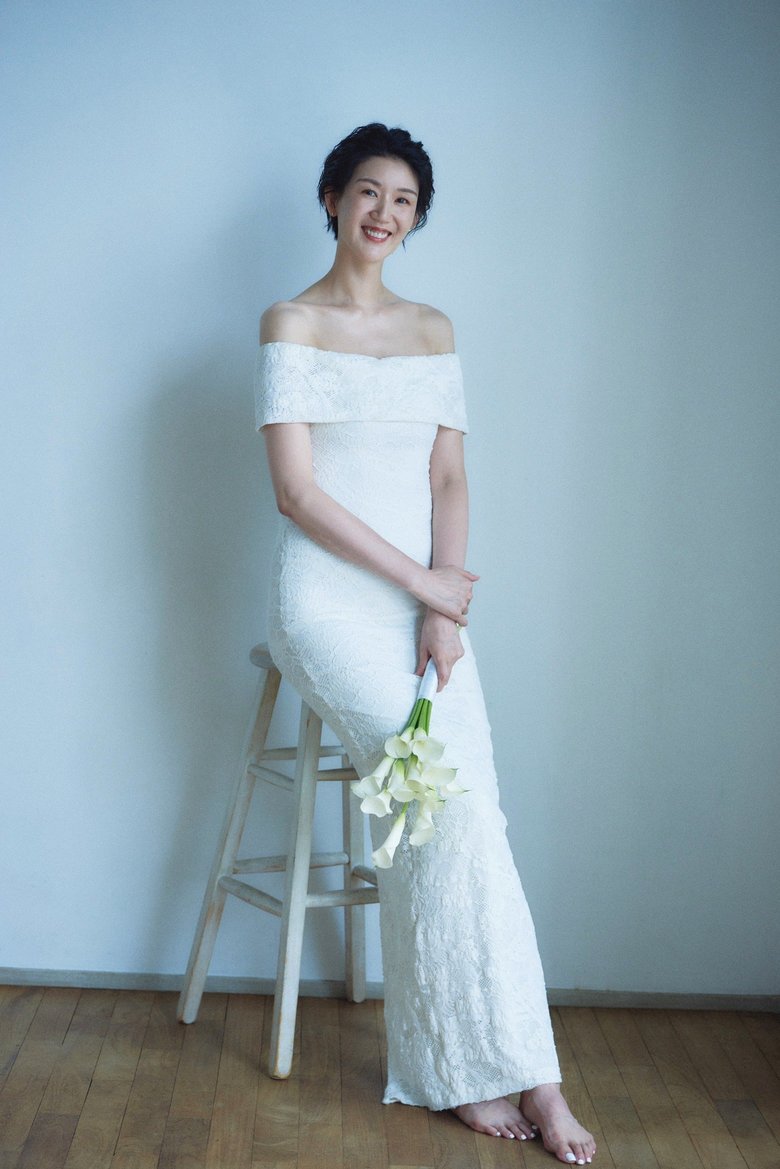 デコルテが見えるマーメイドドレスで幸せいっぱいの笑顔を見せる