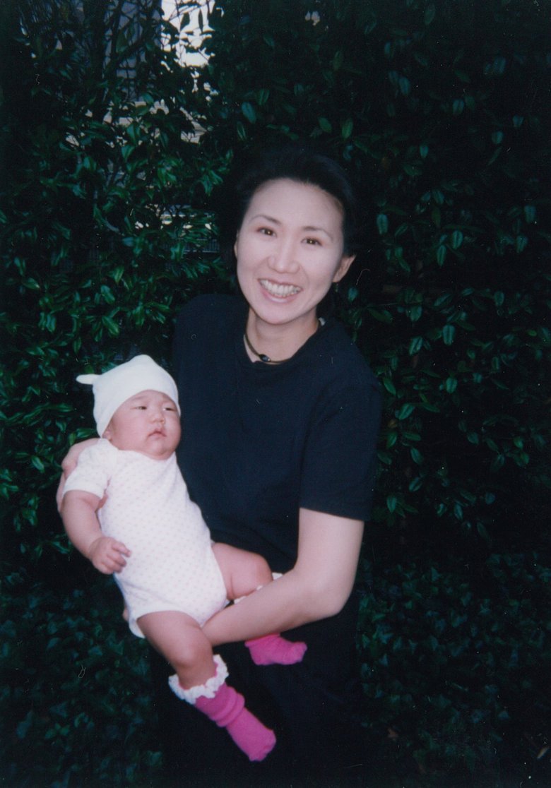 生後3か月の娘を抱き、母親としてはつらつとした表情の高橋さん