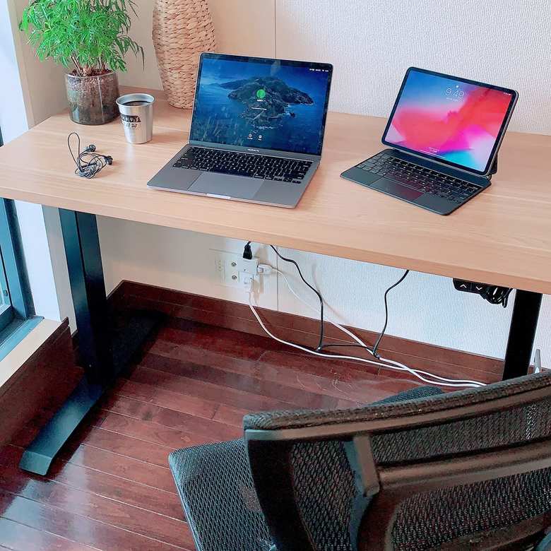 ピープル＆ブランド本部の山田葉月さんの自宅ワークスペース。「社内チャットを参考にFLEXISPOTの電動式昇降デスクをチョイス。椅子はオフィスで使用しているものを配送してもらいました」（山田さん）