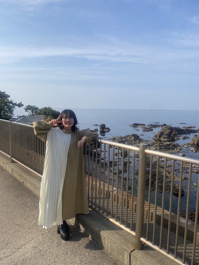 海をバックに、穏やかな笑顔の阿部さん